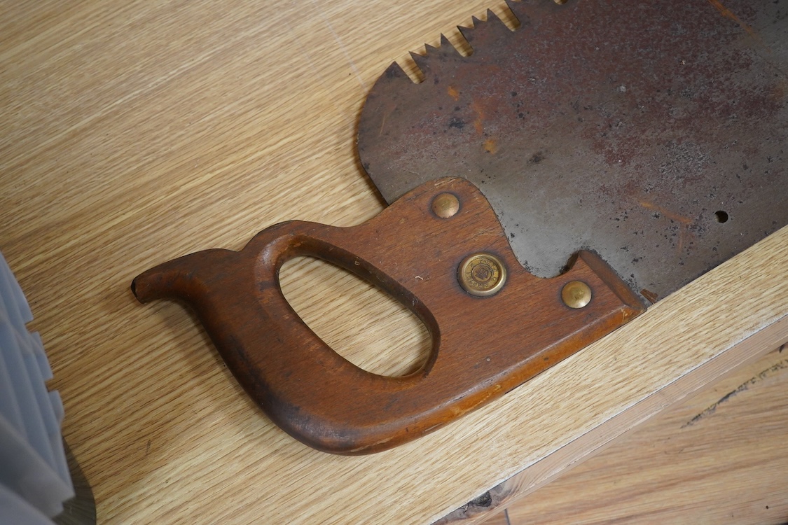 Three large Henry Disston and Sons, Philadelphia, U.S.A. early 20th century hand saws, the largest with a 5’ blade, the makers name still clear on two of the blades, all with similar style wood handles